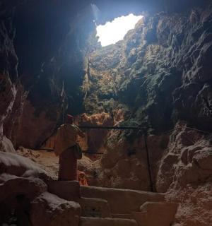 a man standing in a cave with a shaft