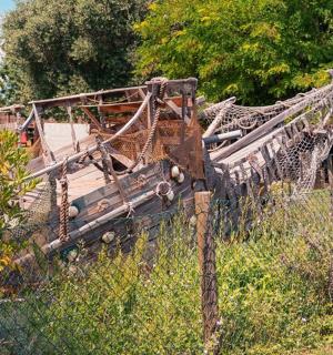 an old boat is sitting behind a fence