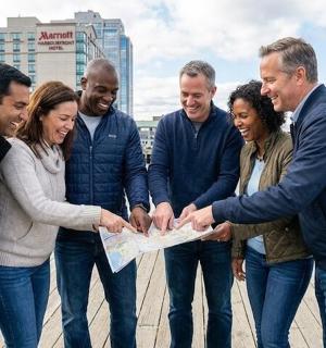 grupp inimesi, kes seisavad grupis ja hoiavad käes kaarti