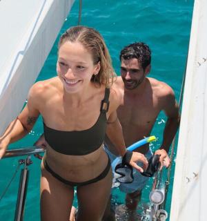 a man and a woman standing on a boat in the water