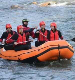 eine Gruppe von Menschen in einem orangefarbenen Floß im Wasser