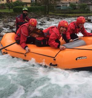 eine Gruppe von Menschen in einem orangefarbenen Floß im Wasser
