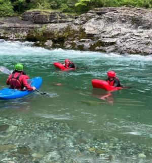 drei Personen in Kajaks im Wasser auf einem Fluss