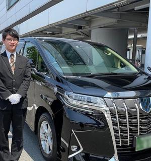 ein Mann im Anzug steht neben einem Auto