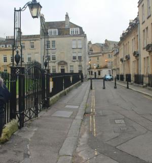 una dona dreta al costat d'una tanca en un carrer