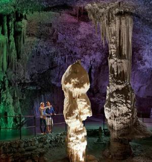 skupina ljudi koja stoji ispred pećine