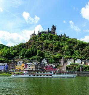 a boat in the water with a town on a hill