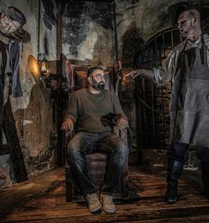 ein Gemälde eines Mannes, der auf einem Stuhl neben zwei Männern sitzt