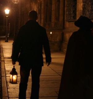 un home i una dona caminant per un carrer a la nit