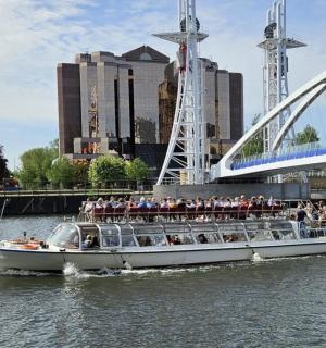 ein Boot voller Menschen auf dem Wasser in der Nähe einer Brücke