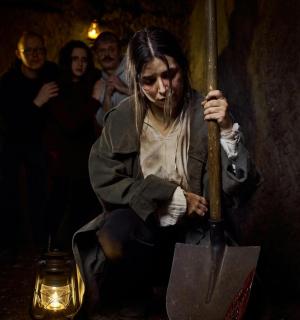 Eine Frau, die im Dunkeln einen Regenschirm hält.