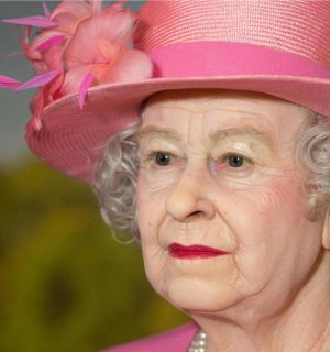 eine ältere Frau, die einen rosa Hut mit Blumen darauf trägt