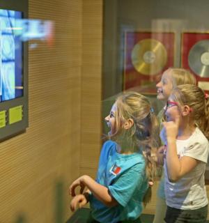 eine Gruppe von Mädchen steht vor einem Fernseher