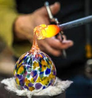 isang taong naggupit ng isang palamuting salamin gamit ang isang gunting