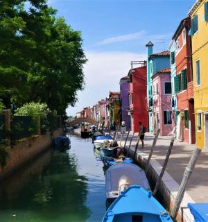 Dva broda su usidrena na kanalu sa šarenim zgradama