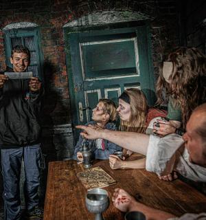 ein Gemälde einer Gruppe von Menschen, die um einen Tisch sitzen