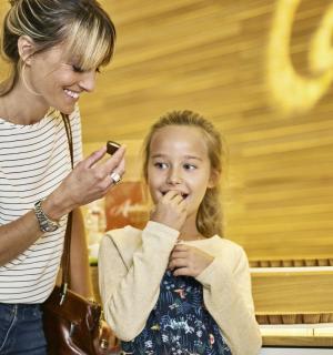 ein junges Mädchen, das auf ein Handy schaut