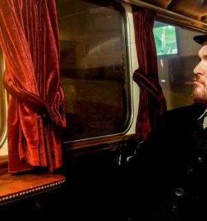 seorang lelaki berjanggut memakai topi dan bertali leher