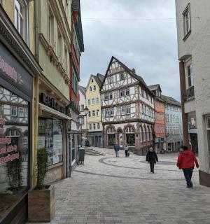 eine Gruppe von Menschen, die eine Straße mit Gebäuden entlanggehen