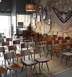 ein Raum mit Stuhlreihen und einer Steinmauer