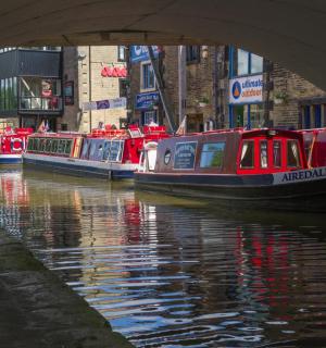 eine Gruppe von Booten auf einem Fluss unter einer Brücke