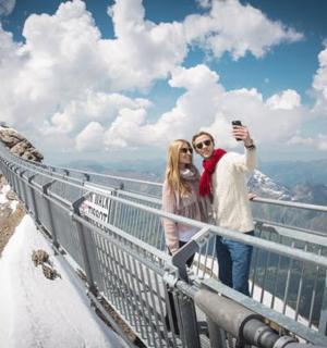 en mand og kvinde tager et billede på toppen af et bjerg