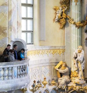 un grup de persones dretes en un edifici amb una estàtua