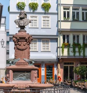 a statue in the middle of a street with buildings