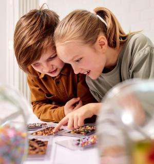 zwei Mädchen schauen auf einen Tisch mit Donuts