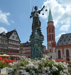 a statue in the middle of a city with buildings