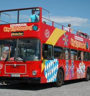 a red double decker bus driving down a street