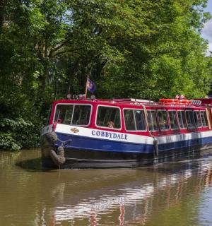 ein rot-weißes Boot, das einen Fluss hinunterfährt