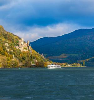 a boat on the water with a castle on a hill