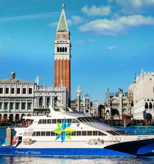 a cruise ship in the water in front of a clock tower