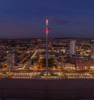 une vue d'une ville la nuit avec une haute tour