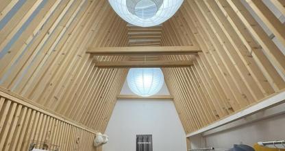 a room with a wooden ceiling with a light fixture