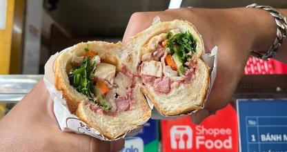 a person holding a sandwich in their hand
