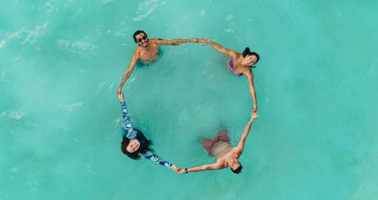 Tres personas están formando un círculo en el agua.
