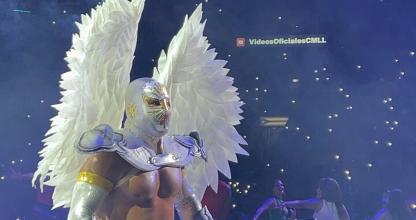Una persona con alas blancas parada frente a una multitud.