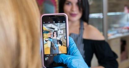 una mujer con guantes azules sosteniendo un teléfono celular