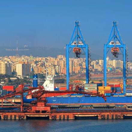a group of cranes in a harbor with a city