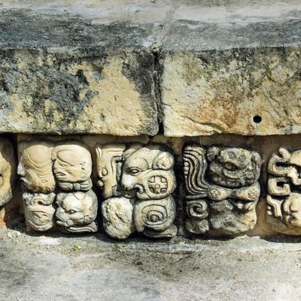 a stone wall with a bunch of statues on it