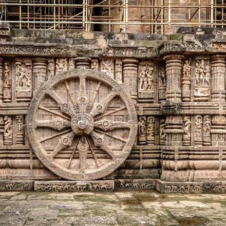 a stone wall with a large stone wheel on it