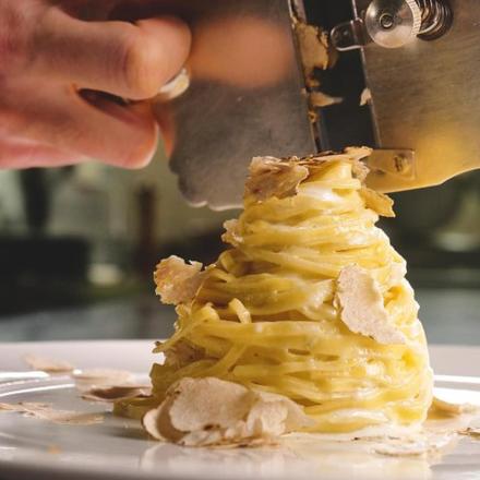 a person cutting a piece of food on a plate