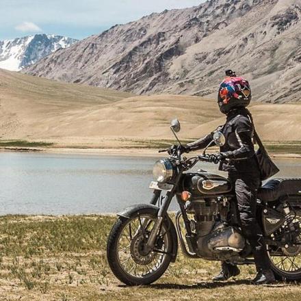 eine Person, die auf einem Motorrad vor einem Berg sitzt