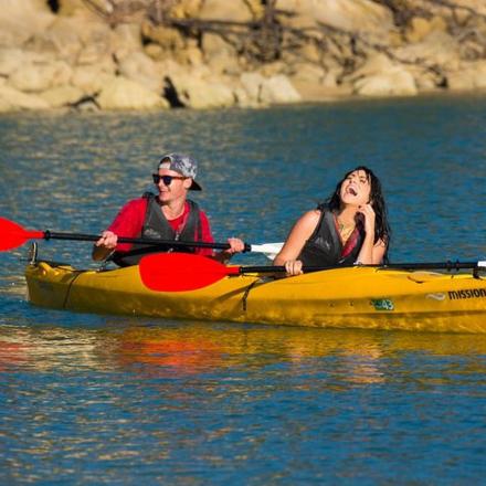 a man and woman in a yellow kayak on the water