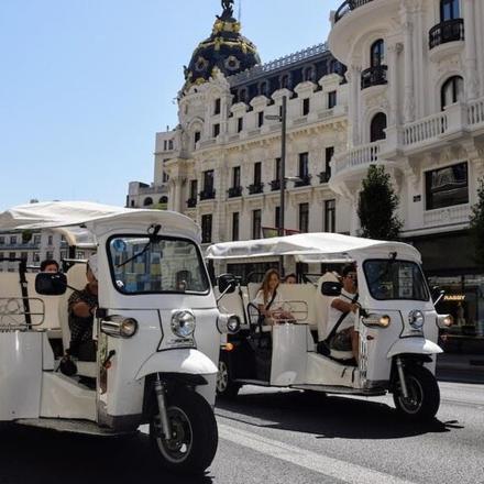 two golf carts driving down a city street