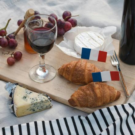 a table with bread and cheese and a glass of wine