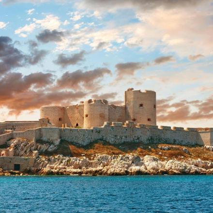 a castle on an island in the water at sunset