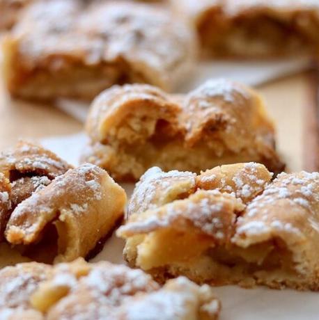 a pile of donuts with powdered sugar on top